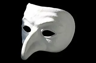 En teatermask i vit med lång näsa.