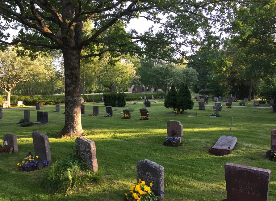 Hovdestalunds begravningsplats med gravstenar på gräsbeklädd mark.