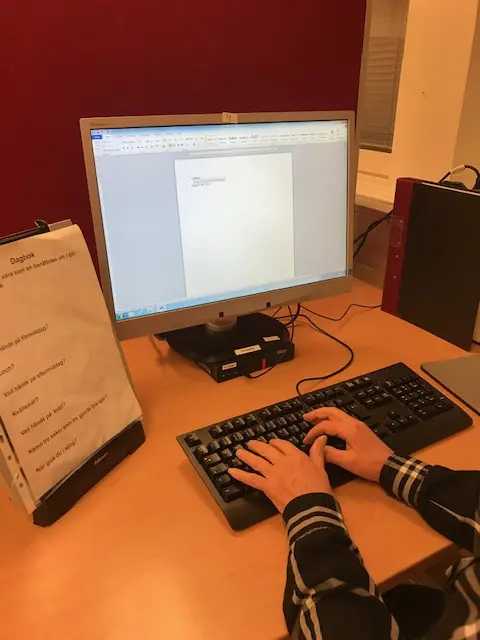 Person sitter och skriver vid en dator. 