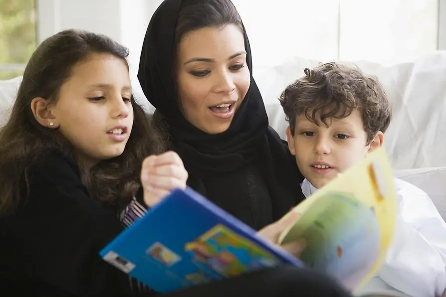 En kvinna läser för två barn.