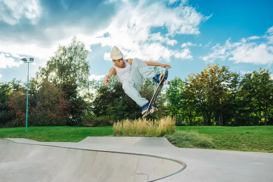 Kille på skateboard som gör trick i luften.