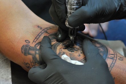 Närbild på en arm som blir tatuerad.